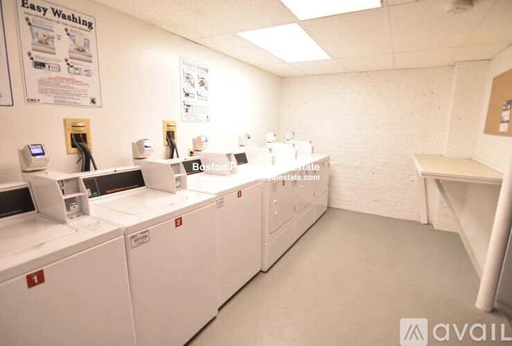 A row of washing machines are lined up in a laundromat.