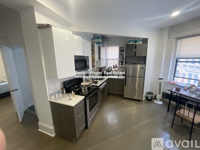 A kitchen with a refrigerator, microwave, and oven.