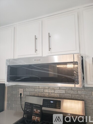 A Whirlpool microwave is installed above a stove.