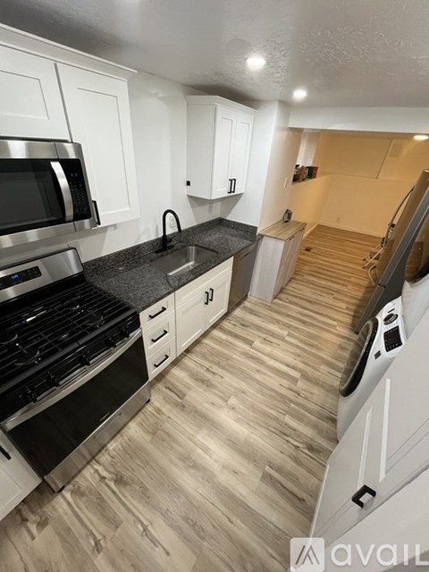 A kitchen with white cabinets and a black countertop.