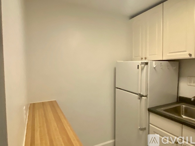 A kitchen with a white fridge and a wooden counter.