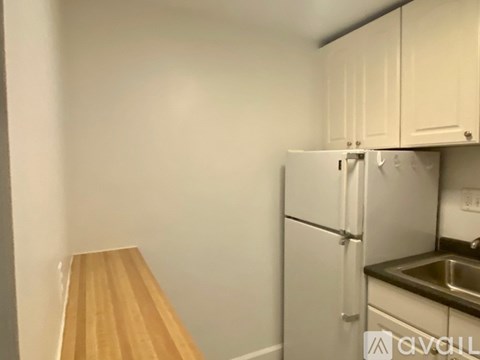 A kitchen with a white fridge and a wooden counter.
