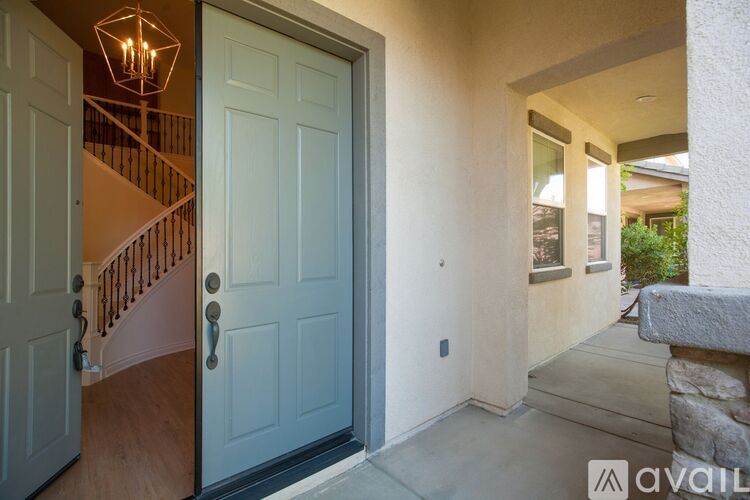 A white door is open to a hallway with a stone wall.