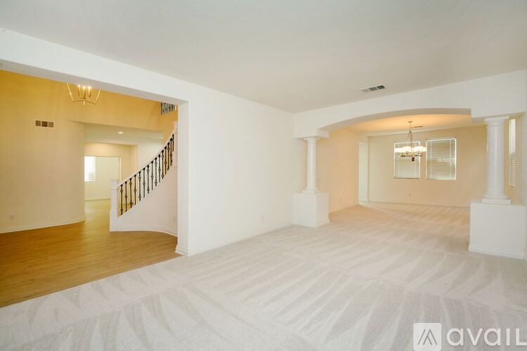 A spacious room with a staircase and a chandelier.