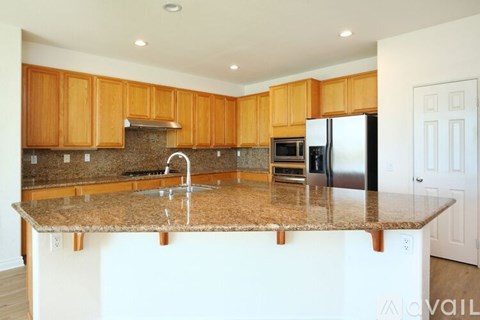 A kitchen with wooden cabinets and granite countertops.