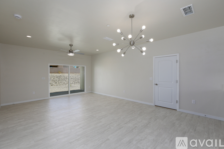 A spacious room with a chandelier and a ceiling fan.