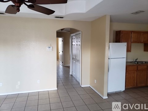 A kitchen with a white refrigerator and a fan on the ceiling.