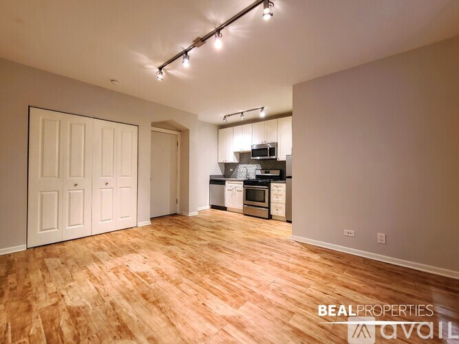 A kitchen area with wooden flooring and a white door.