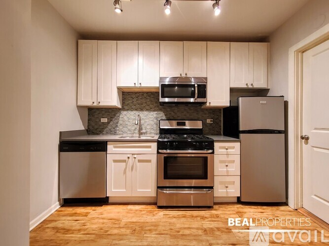A kitchen with white cabinets and stainless steel appliances.