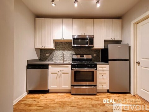 A kitchen with white cabinets and stainless steel appliances.