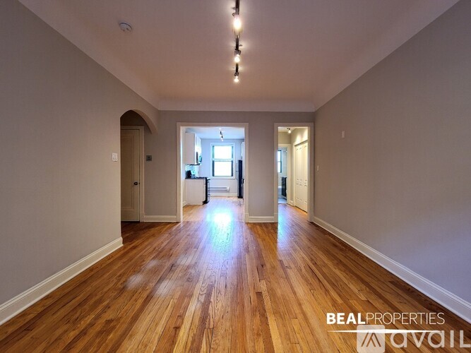A spacious room with wooden floors and a bright light source in the middle.
