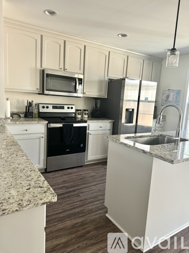 A kitchen with a granite counter top and stainless steel appliances.