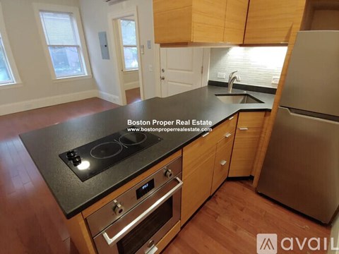 A kitchen with wooden cabinets and a black countertop.