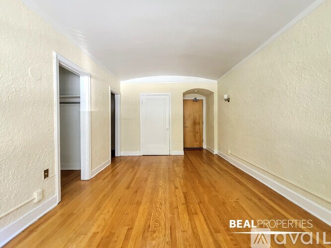 A long hallway with wooden floors and white walls.