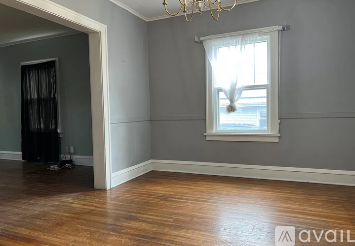 A room with a window and a chandelier.