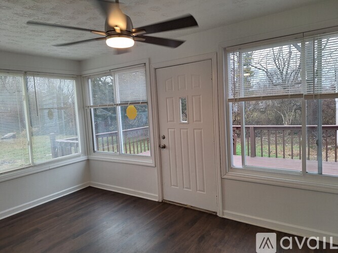 A room with a ceiling fan and sliding glass doors.