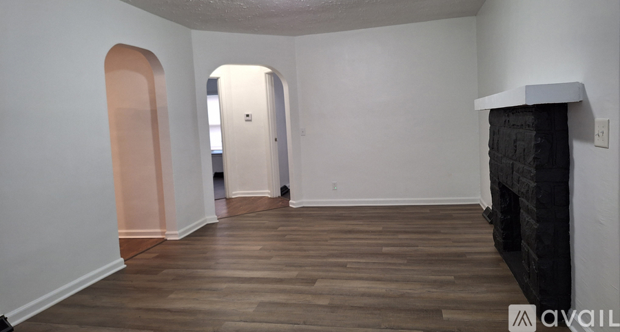 A room with a fireplace and wood flooring.