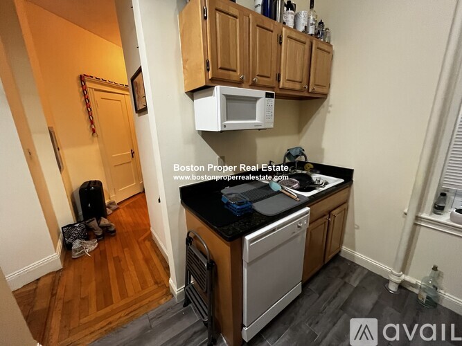 A kitchen with wooden cabinets and a black countertop.