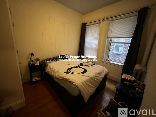A bedroom with a bed, nightstand, and window.