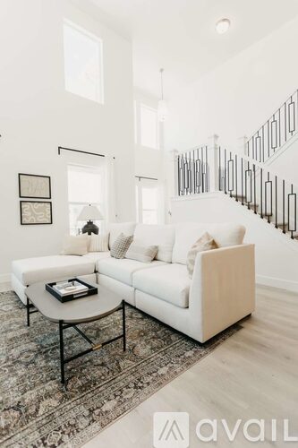 A white sofa with a black coffee table in a spacious room.