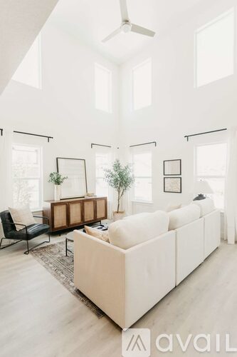A modern living room with a white sofa and a black chair.