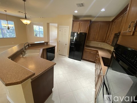 A kitchen with brown cabinets and black appliances.