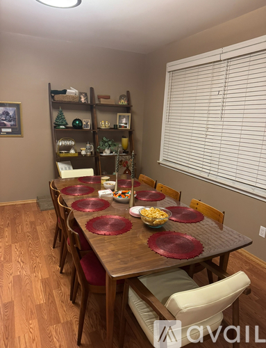 A dining room with a wooden table and chairs.
