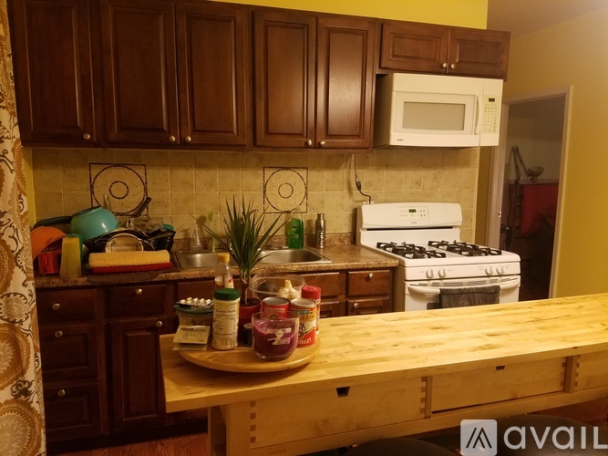 A kitchen with wooden cabinets and a white stove.