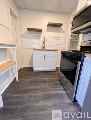 A kitchen with a stove top oven and a white cabinet.