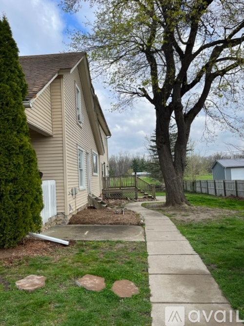 A house with a tree and a fence in the backyard.