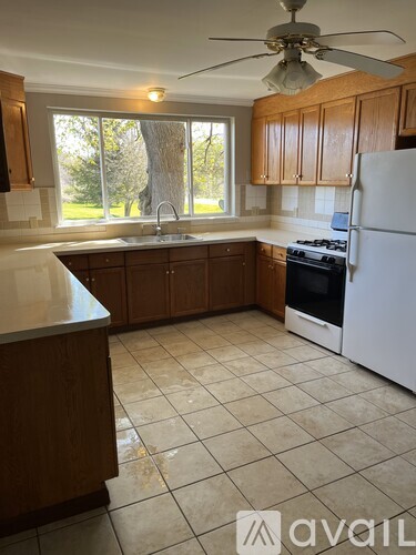 A kitchen with a white fridge and wooden cabinets.