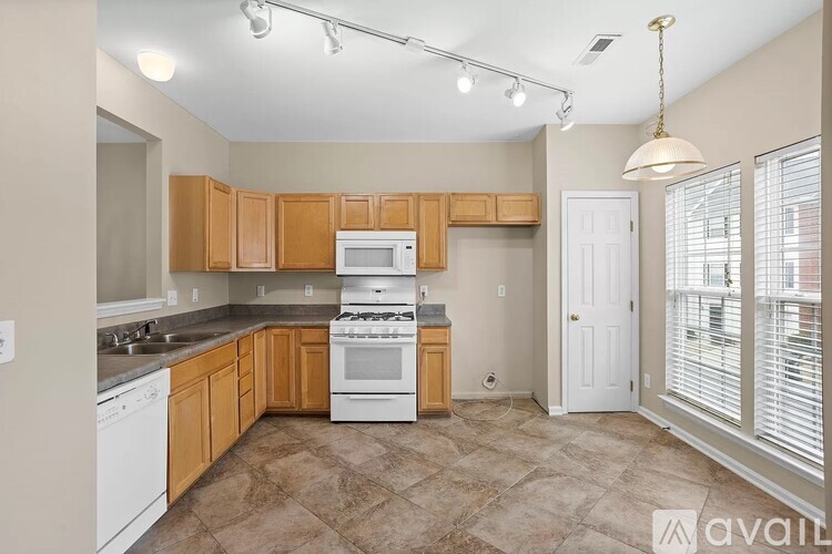 A kitchen with wooden cabinets and a white stove top oven.