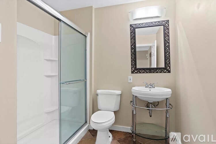 A bathroom with a toilet, sink, and shower.