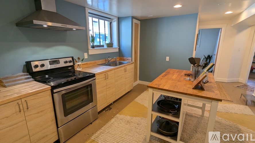 A kitchen with a stove top oven and a wooden island.
