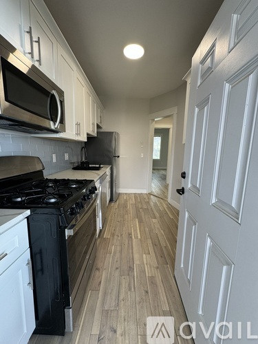 A kitchen with a black stove top oven and white cabinets.