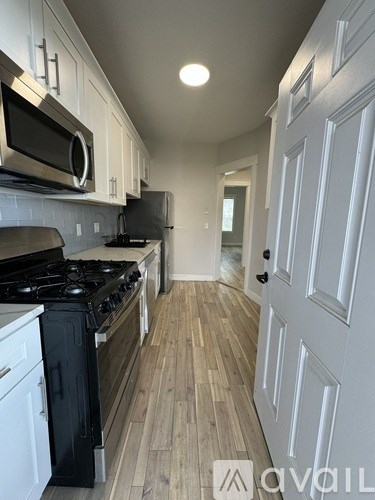 A kitchen with a black stove top oven and white cabinets.
