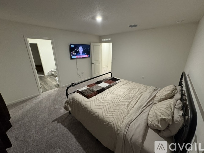 A bedroom with a bed, a television, and a mirror.