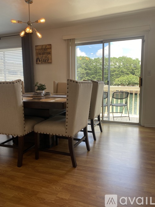 A dining room with a table and chairs and a view of the backyard.