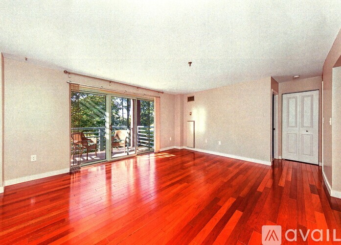 A room with wooden floors and a sliding glass door leading to a patio.