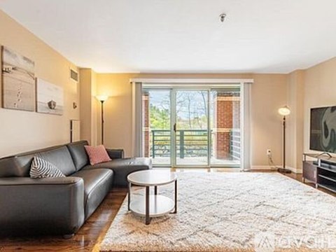 A living room with a black couch and a coffee table.