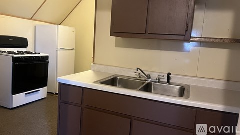 A kitchen with a white stove and brown cabinets.