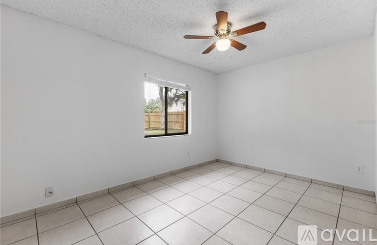 A room with a ceiling fan and a window.