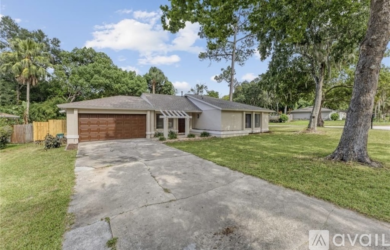 A house with a driveway and trees in the background.