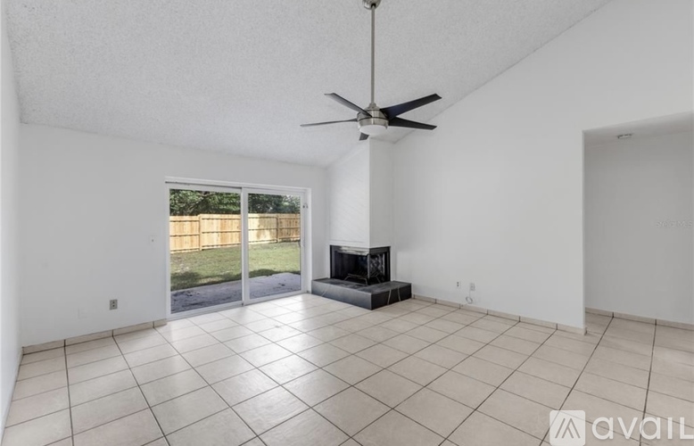 A spacious living room with a fireplace and sliding glass doors.