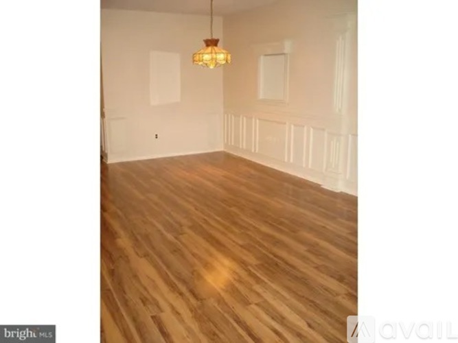 A room with wooden flooring and a chandelier.