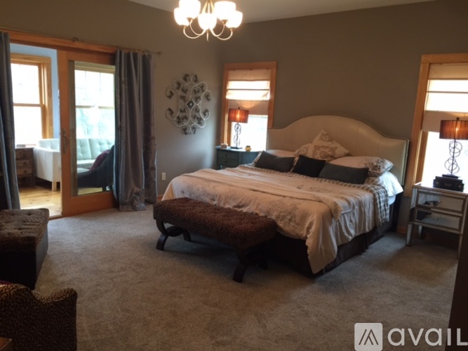 A bedroom with a large bed and a chandelier.