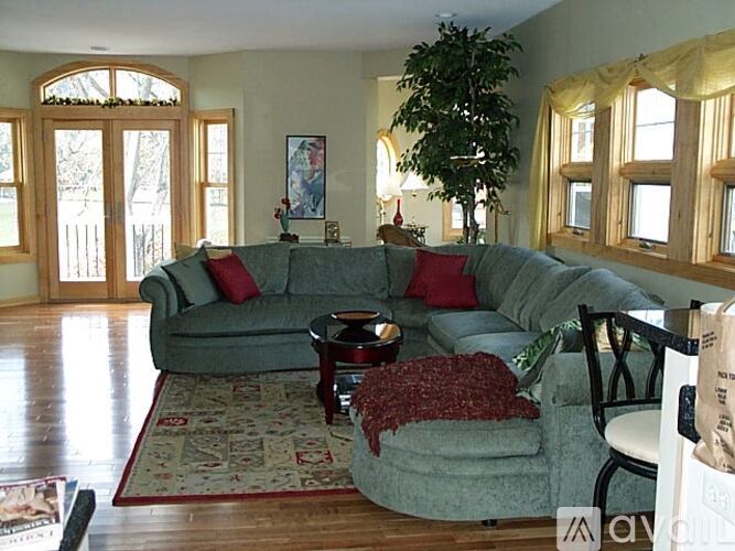 A living room with a grey couch and a red throw.