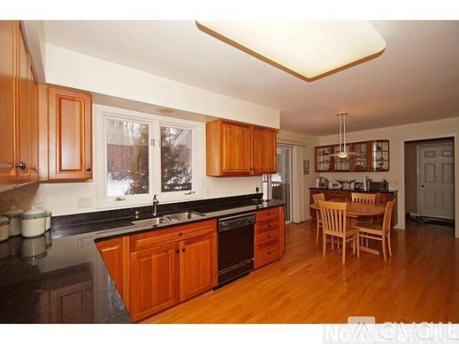 A kitchen with wooden cabinets and a black countertop.