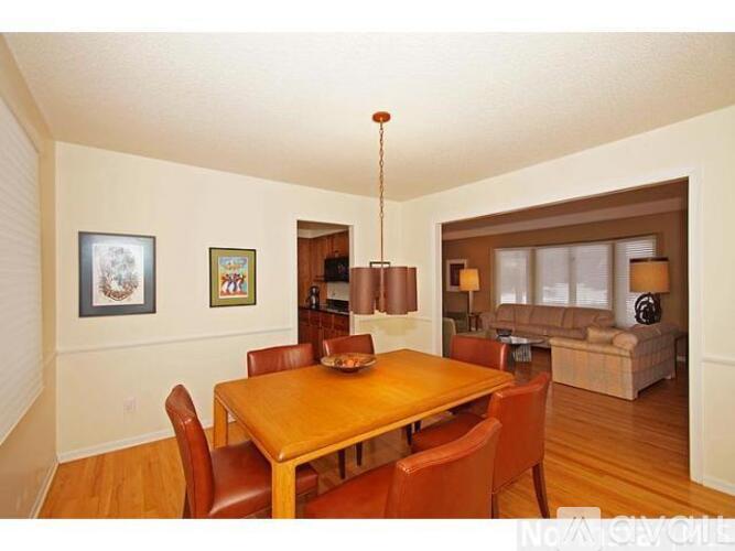 A dining room with a wooden table and chairs.