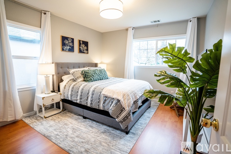 A bedroom with a large bed and a plant.